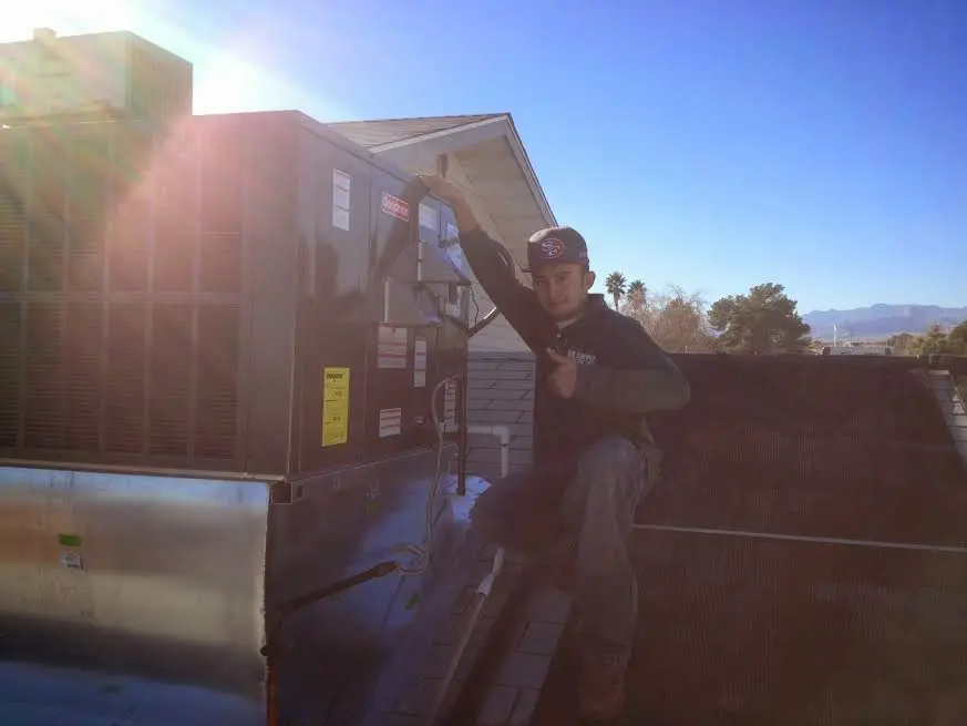 HVAC technician performing AC Tune-Up on a rooftop unit in Morristown